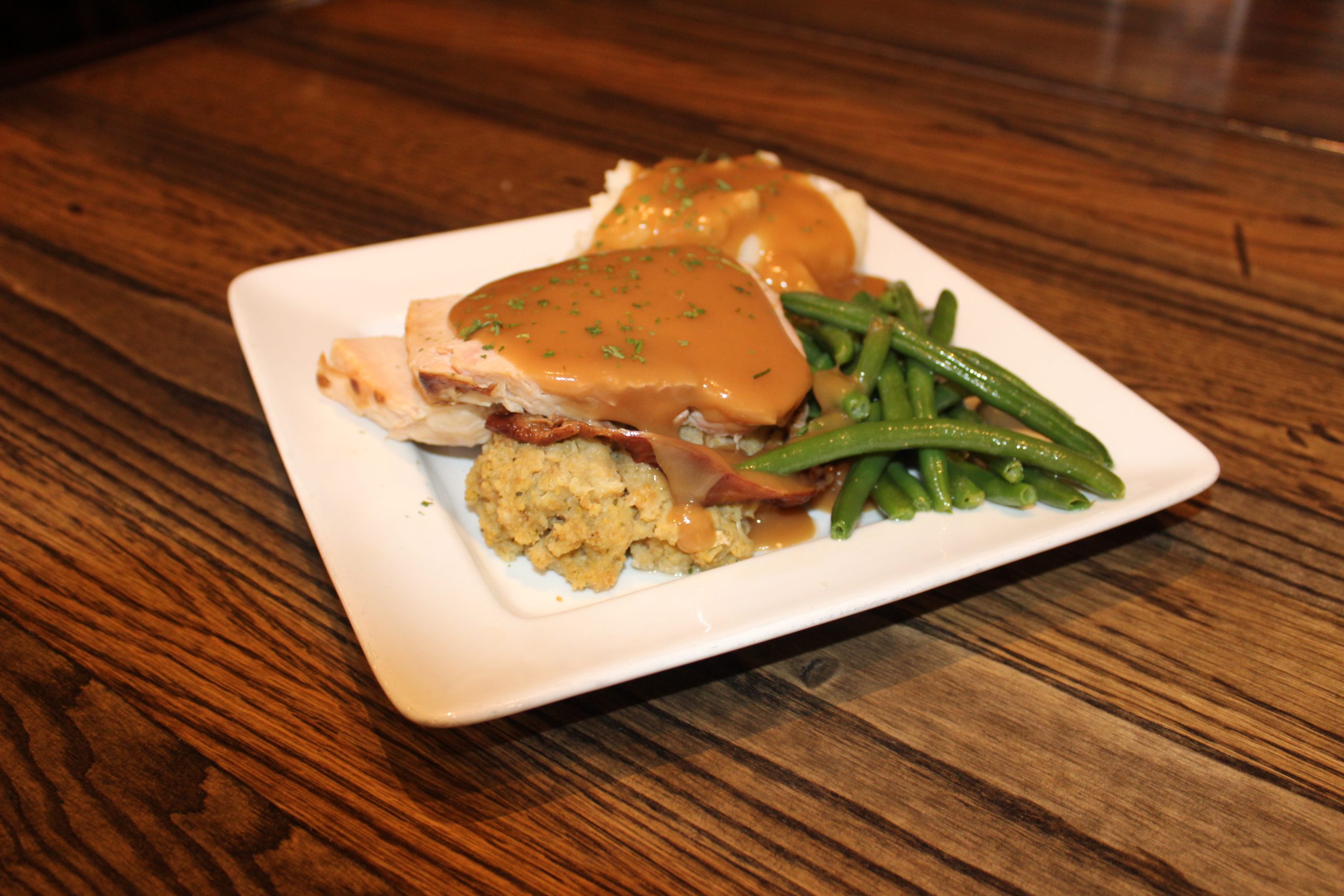 Turkey and Dressing : In House Smoked Turkey Breast with cornbread stuffing, mashed potato, sautéed green beans topped with turkey gravy. $12.99  